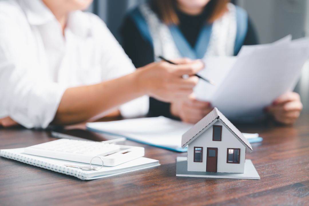 Verträge zum Kauf einer Immobilie mit einem kleinen Hausmodell - Baufinanzierung trotz Krankengeld_1080x720